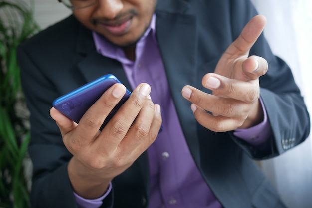 Close up of young man hand using smart phone