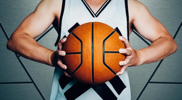 Close up of young man midsection holding a basketball