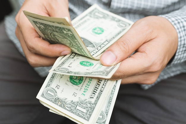 Close up young man standing  hand hold Count the money spread of cash.