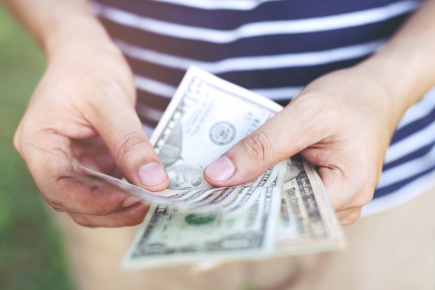 close up young man standing  hand hold Count the money spread of cash.