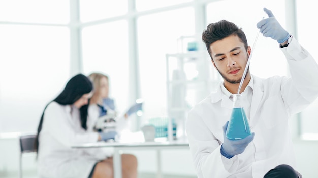 Close up the young scientist makes the analysis of the liquid