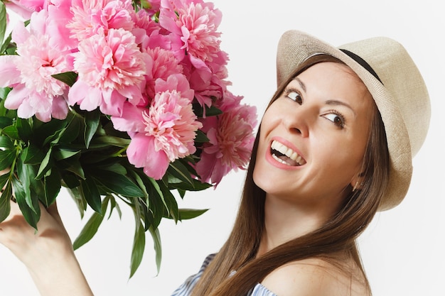 Close up young tender woman in blue dress, hat holding bouquet of pink peonies flowers isolated on white background. St. Valentine's Day, International Women's Day holiday concept. Advertising area.