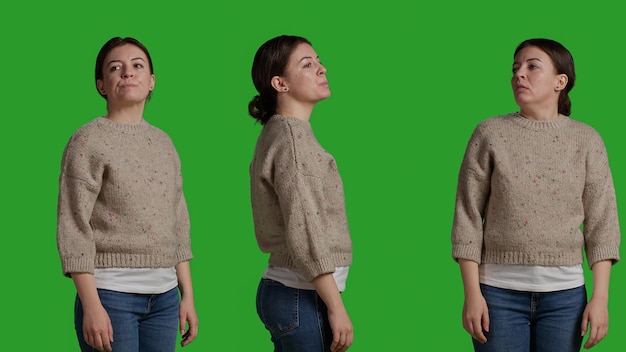 Close up of young woman posing and standing in front of camera, acting casual and relaxed. Caucasian person with sweater looking confident and stylish over green screen background.