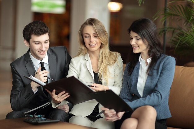 Close upcolleagues discussing the financial document in the lobby of the Bank