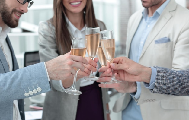 Close upglasses of champagne in the hands of the business teamthe concept of teamwork