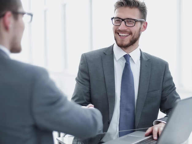 Close upsmiling business people shaking hands in office