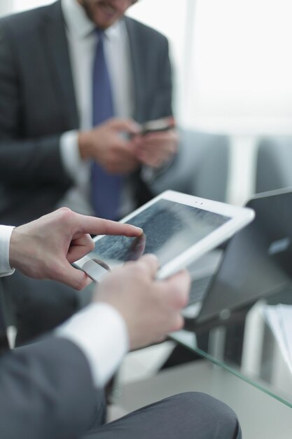 Close upthe businessman uses a digital tablet in the workplace