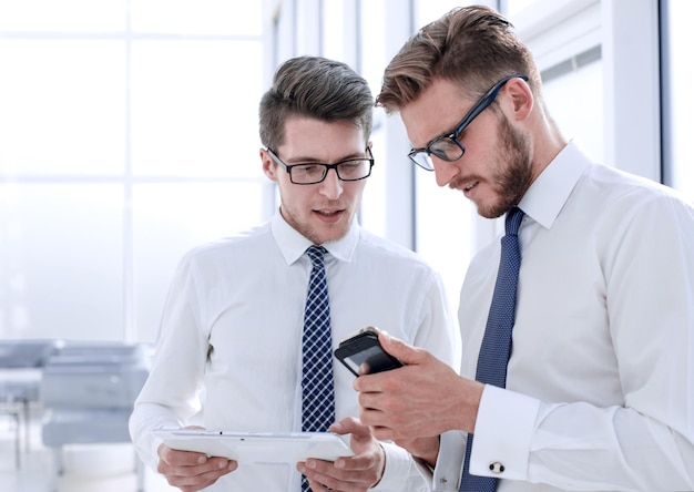 Close upyoung employees use gadgets in their office