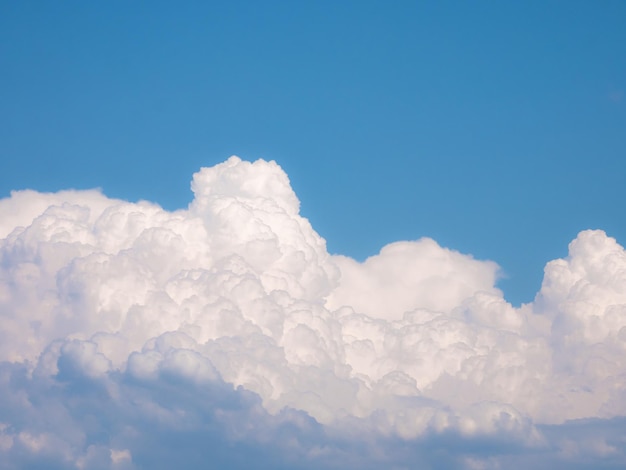 Close view of cumulus storm clouds and the strange shapes they form as they move and a blue sky in the background