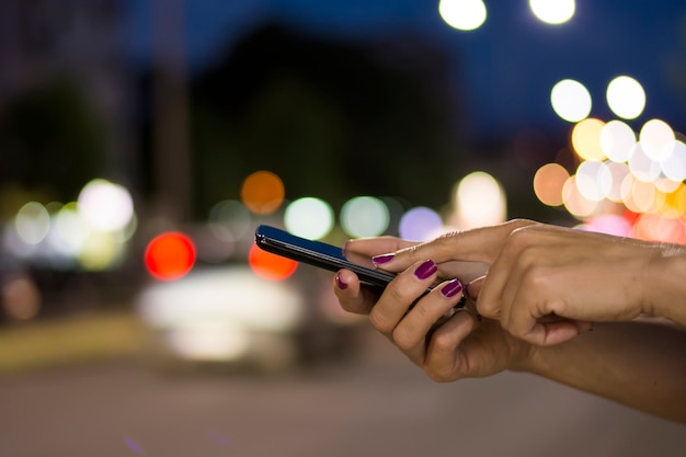 Close View of Female Hand Holding Smart Phone During Night