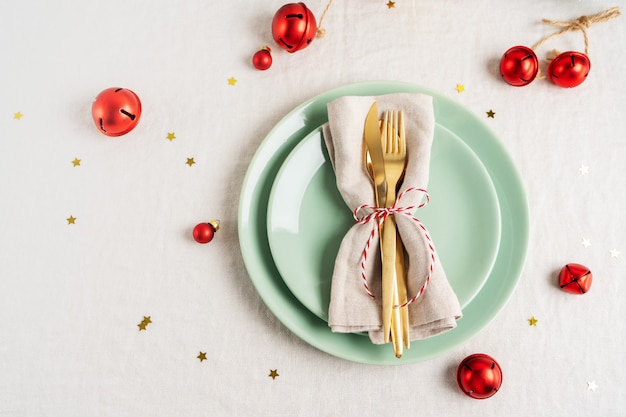 Close view of golden cutlery on light napkin for Christmas table setting.