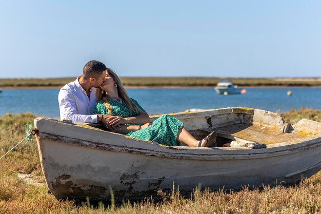 Close view of a happy young european couple holding together next to wooden boat