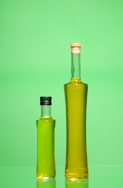 Photo closed bottles of olive oil isolated on green