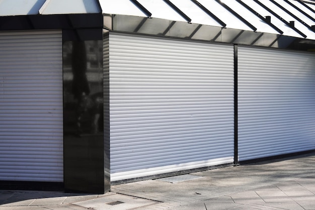 Closed business shop or store front with roller shutters