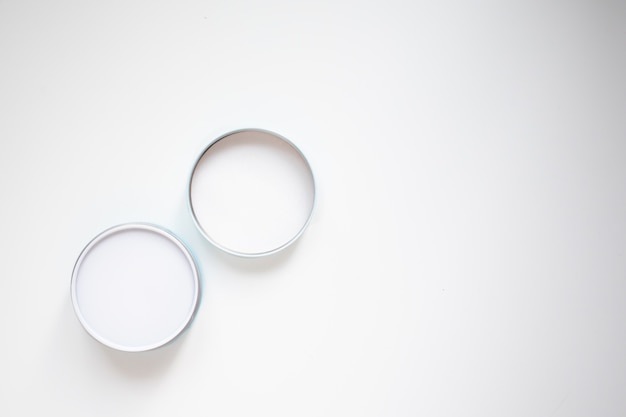 Closed cosmetics jar and lid on a white background top view with copy space