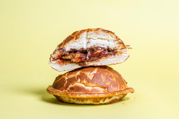 a closed cut burger with juicy filling on a yellow background