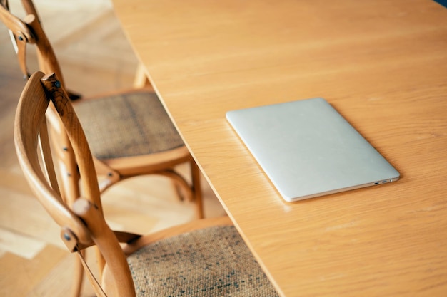 A closed laptop is lying on the desk in the office