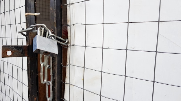 Closed padlock on a hangar from a grid and a white banner.