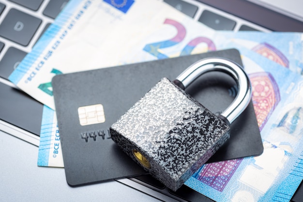 Photo closed padlock with money and credit card on laptop keyboard