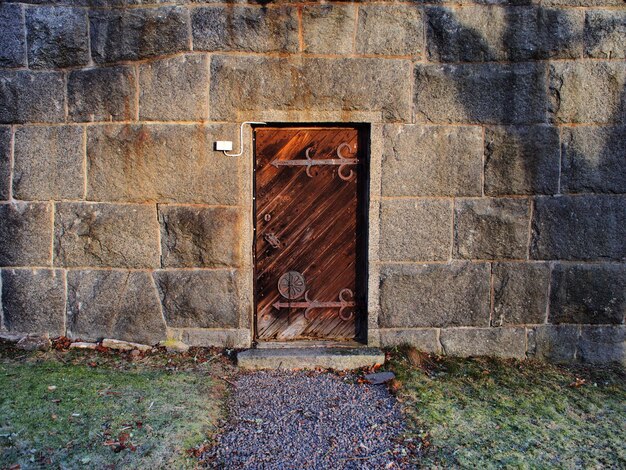 Photo closed rusty door amidst concrete wall