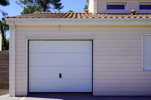 Closed shutter door roller white garage gate in home wooden facade wall street entrance