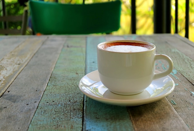 Closed up a Cup of Hot Cappuccino Coffee Served on Rustic Style Wooden Table