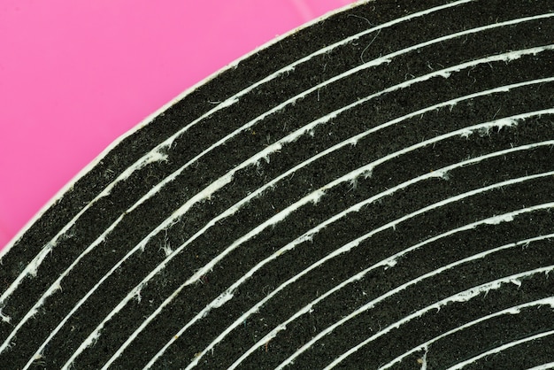 Closed up of double sided tape roll with pink background