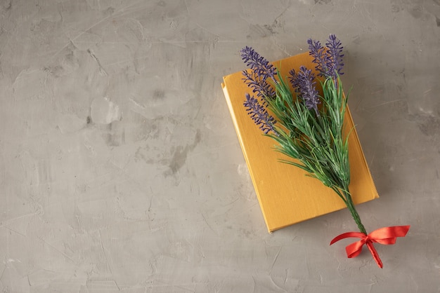 Closed yellow book and lavender branch