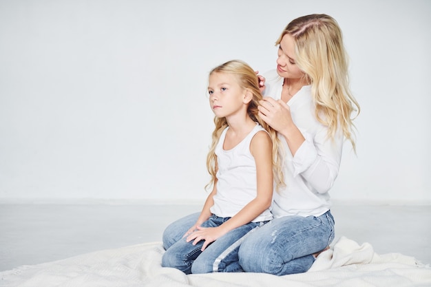 Closeness of the people. Mother with her daughter together in the studio with white background.