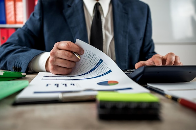 Closeup of accountant hand work with accountancy document chart and diagram