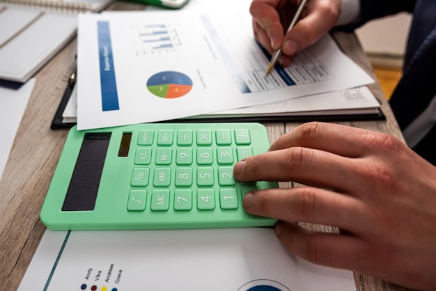 Closeup of accountant hand work with accountancy document chart and diagram