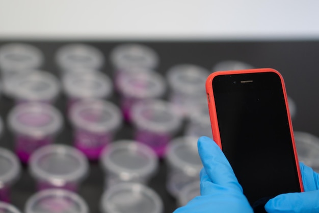 Closeup of anonymous woman using her phone in the laboratory