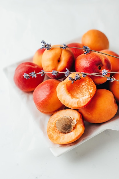 Closeup on apricots with a sprig of lavender on a white background