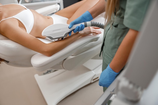 Closeup of arm hair laser removal with ipl machine by a professional cosmetologist