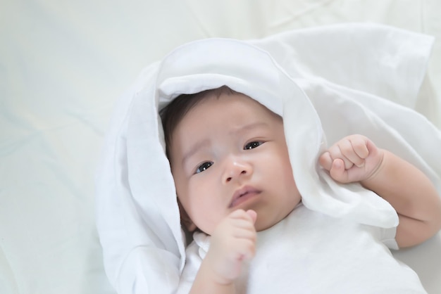 Closeup asian baby lying on the bedCute thailand little girl