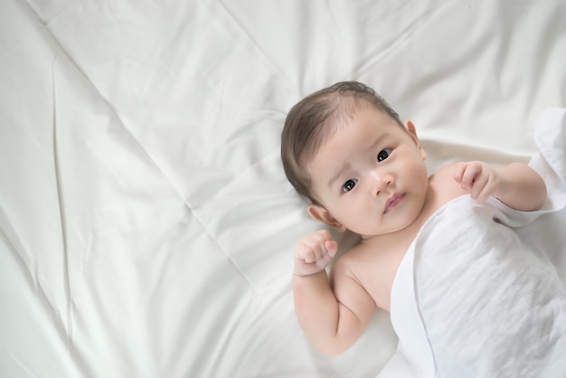 Closeup asian baby lying on the bedCute thailand little girl