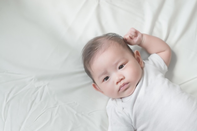 Closeup asian baby lying on the bedCute thailand little girl