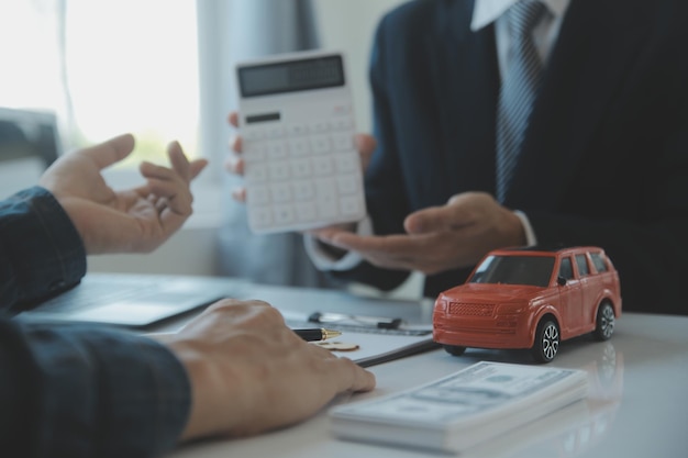 Closeup asian male people car salesman or sales manager offers to sell a car and explains and reads the terms of signing a car contract and insurance