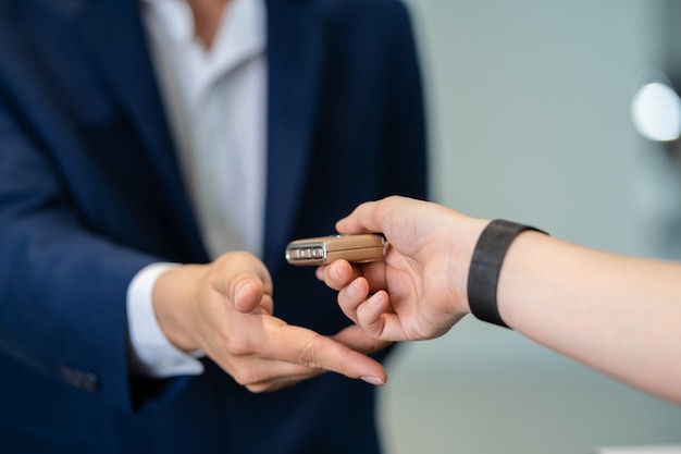 Closeup Asian receptionist hand recieving the automatic car key for checking