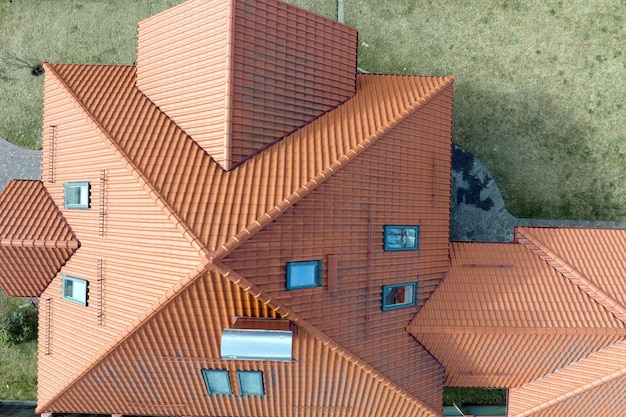 Closeup of attic windows on house roof top covered with ceramic shingles Tiled covering of building