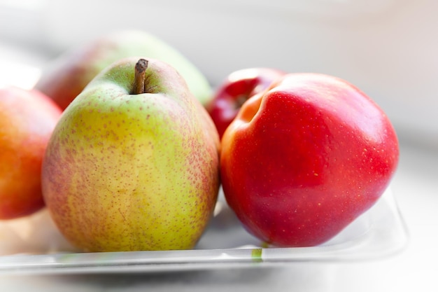 Closeup autumn fruits on a plate Pears and apples are stacked in a plate Selective soft focus