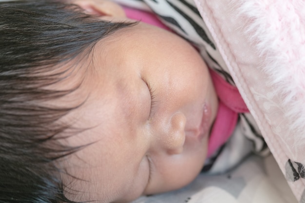 Closeup a baby sleeping comfortably on the bed