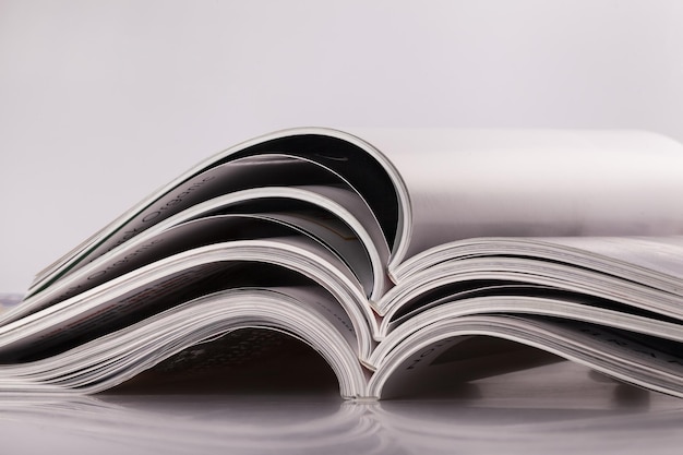 Closeup background of a pile of old magazines with bending pages. Small shallow dof.