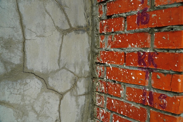 Closeup of badly fixed building facade wall covered with cracks