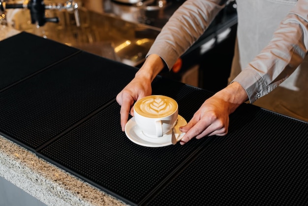 Closeup of a barista serving exquisite delicious coffee on the bar during a pandemic Preparation and serving in a coffee shop