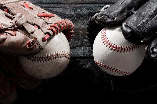 Closeup baseball glove and baseball on wood board dark theme sport concept