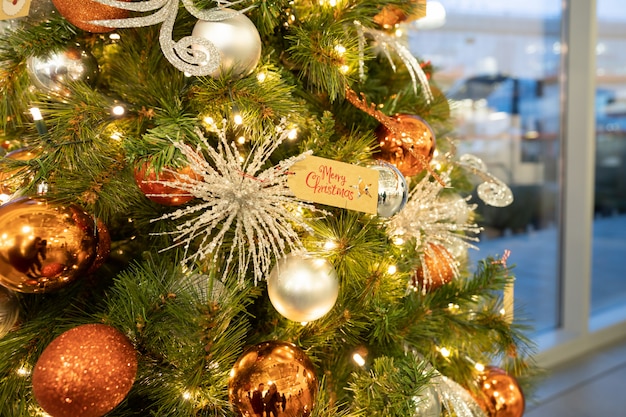 Closeup of bauble balls hanging from a decorated Christmas tree.