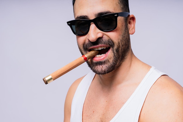 Closeup bearded caucasian man smoking a cigar Wearing white shirt Studio portrait