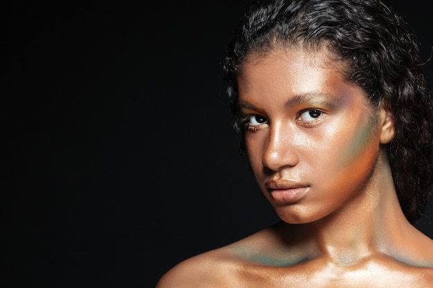 Closeup of beautiful american young woman with stylish makeup over black