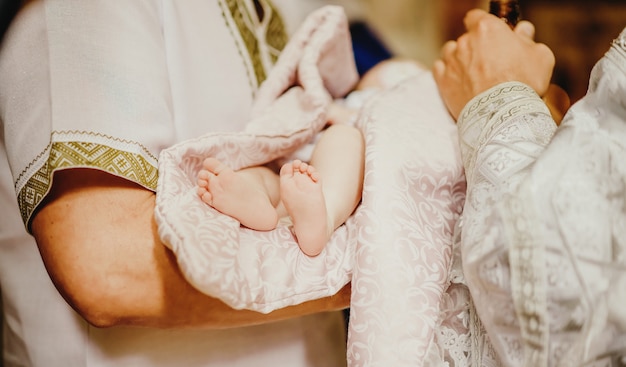 Closeup of beautiful feet of newborn baby lying on father's arms